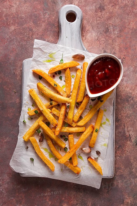 Fried French fries, in a paper bag, on an abstract background, no people, rustic