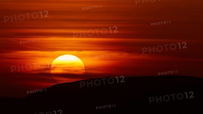A fascinating sunset, where the setting sun bathes the sky in shades of red and disappears behind a hill, offshore island, Kritinia Castle, St John's Castle, Kritinia, Rhodes, Dodecanese, Greek Islands, Greece, Europe