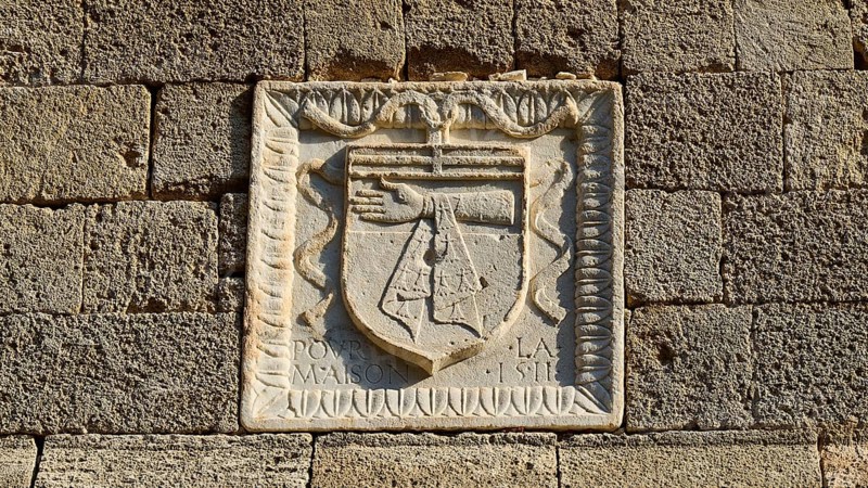 Square stone relief with a coat of arms showing an arm on a historic wall, Knights Street, Rhodes Old Town, Rhodes Town, Rhodes, Dodecanese, Greek Islands, Greece, Europe