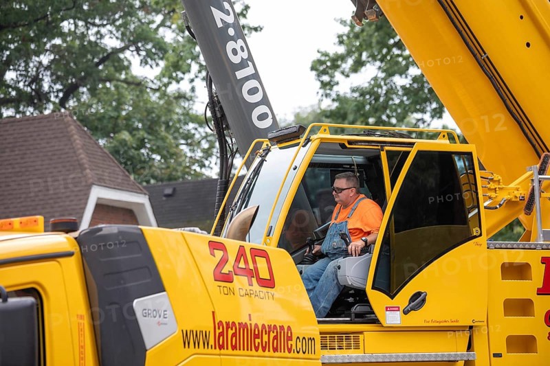 Detroit, Michigan, A storm with 70mph wind gusts blew down a 15-ton, 110-foot cottonwood, damaging three homes in the Morningside neighborhood. A dozen workers used two cranes, bucket trucks, and other equipment to remove the tree. A crane operator guides his 240 ton truck-mounted crane