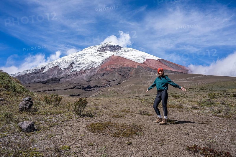 Women poses in front of the Cotopaxi volcano, Cotopaxi, Cotopaxi National Park, Latacunga, Ecuador, South America