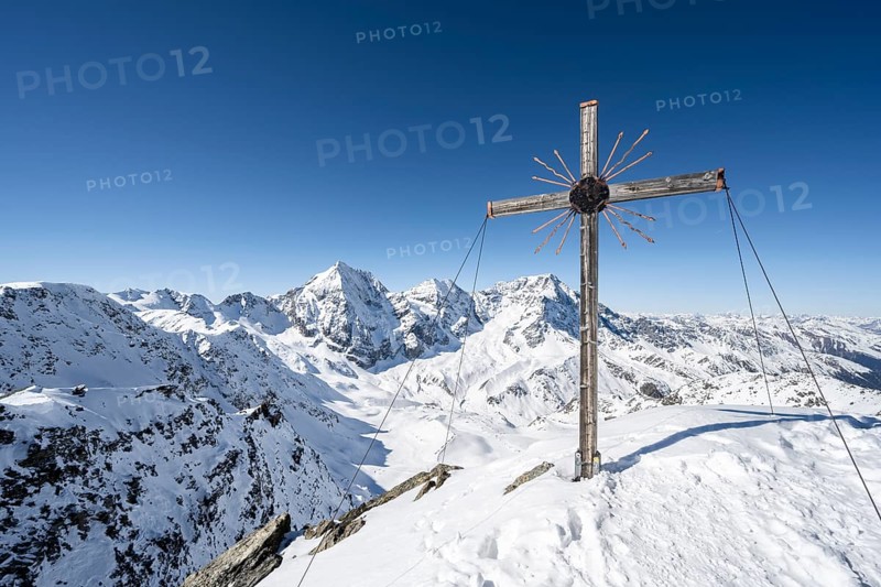 Summit cross at the summit of the Madritschspitze, mountain panorama with snow-covered mountain landscape in winter, view of mountain peaks Königsspitze, Monte Zebru and Ortler, Ortler Alps, Vinschgau Valley, Italy, Europe