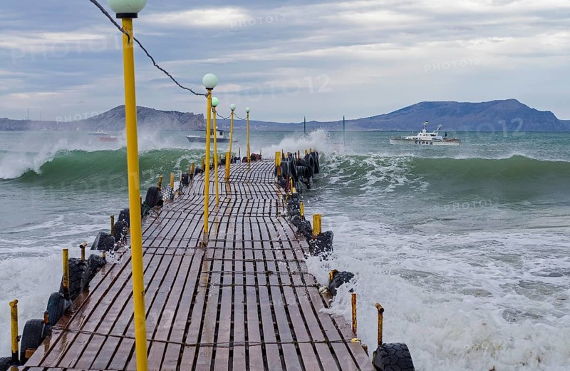 Wave fills a small jetty. Crimea, the Black Sea coast