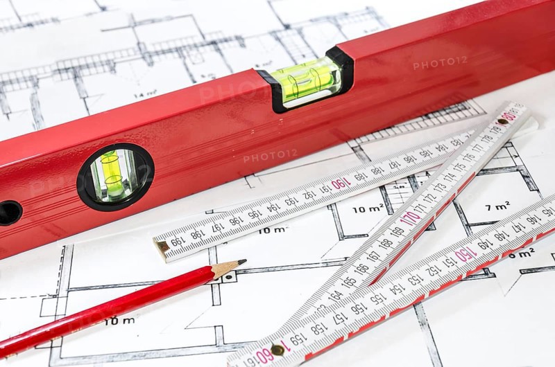 Spirit level, pencil and yardstick on a construction plan