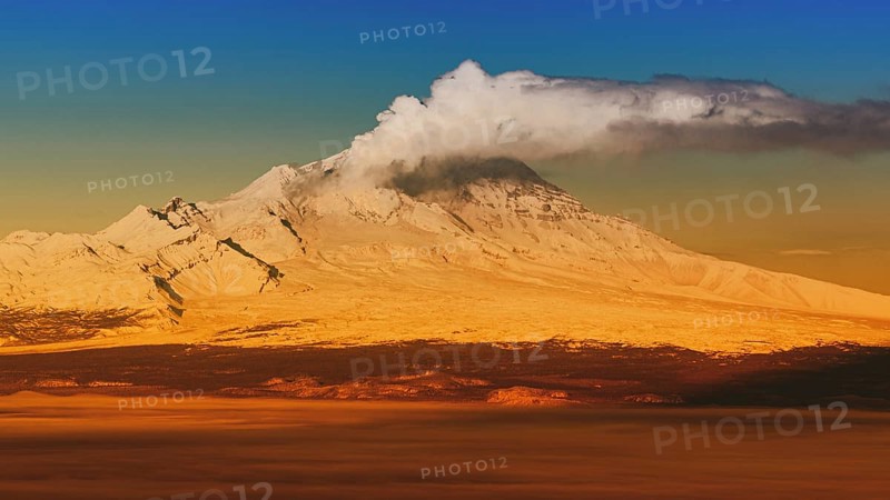 Eruption crater active volcano on Kamchatka Peninsula, winter volcano landscape at sunrise. Colorful picture with filter noise and grain, effect of old film, vintage instant color photo effect