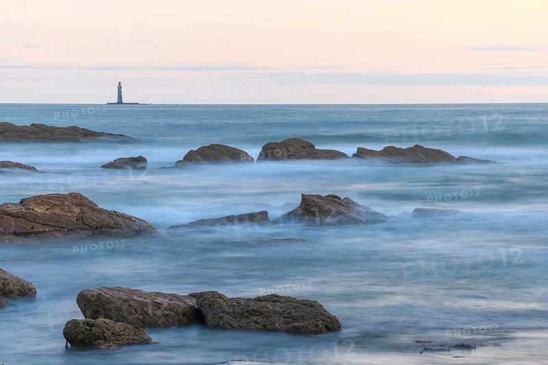 The lighthouse of the barges on the horizon seen from the beach of Sauveterre. Les Sables d'Olonne, Vendee, Pays de la Loire, France, Europe