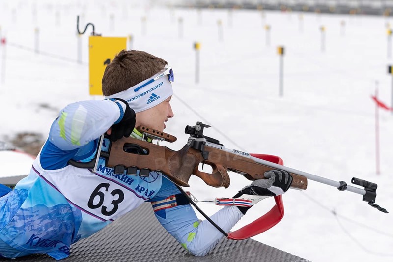 Sportsman biathlete Morilov Mikhail Khanty-Mansiysk rifle shooting in prone position. Biathlete in shooting range. Open regional youth biathlon competitions East Cup. Kamchatka, Russia, Apr 12, 2019, Europe