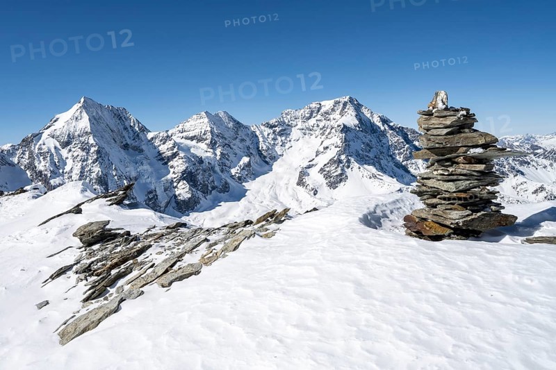 Cairns in the snow, mountain panorama with snow-covered mountain landscape in winter, view of mountain peaks Königsspitze, Monte Zebru and Ortler, summit of Madritschspitze, Ortler Alps, Vinschgau Valley, Italy, Europe