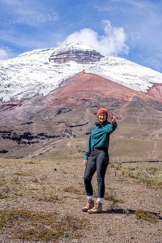 Women poses in front of the Cotopaxi volcano, Cotopaxi, Cotopaxi National Park, Latacunga, Ecuador, South America