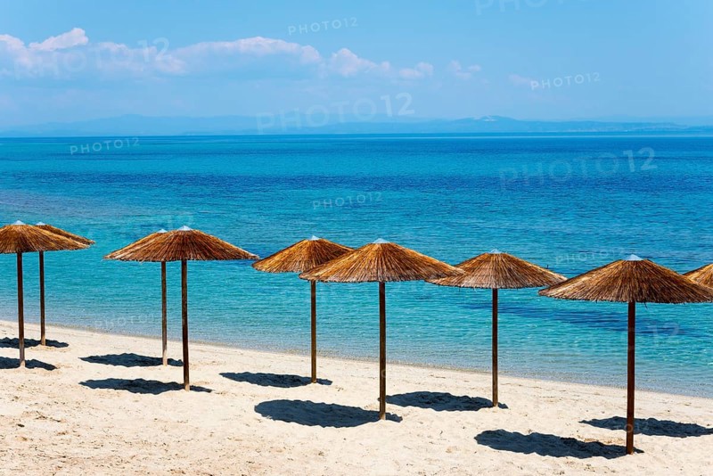 Sandy beach beach with thatched roofs and clear blue sea under a sunny sky, Golden Beach, Pallini, Palioúri, Kassandra, Chalkidiki, Halkidiki, Central Macedonia, Greece, Europe