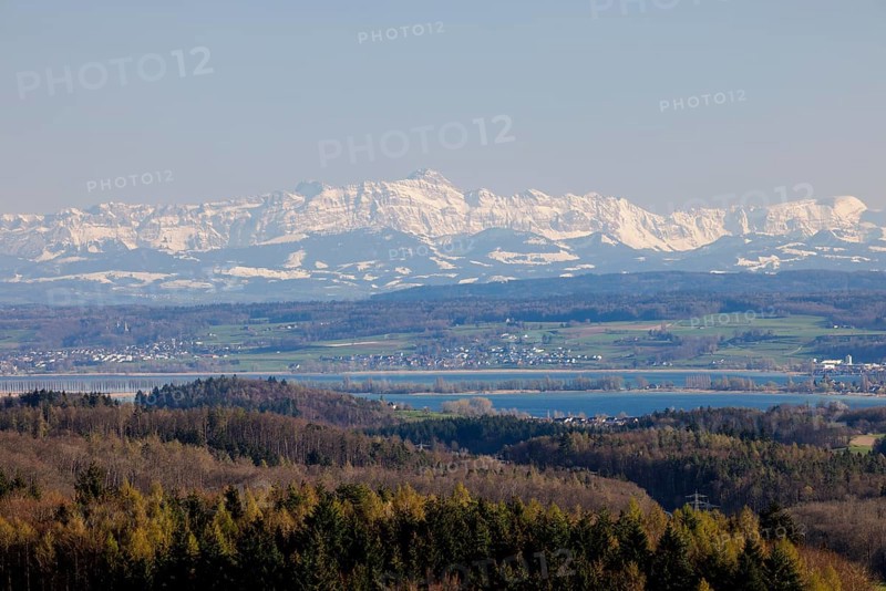 A wide landscape with a lake and snow-capped mountains of Säntis in the Alpstein in the background under a clear sky, Schneckenebrg, Liggeringen, Lake Constance, Baden-Württemberg, Germany, Europe