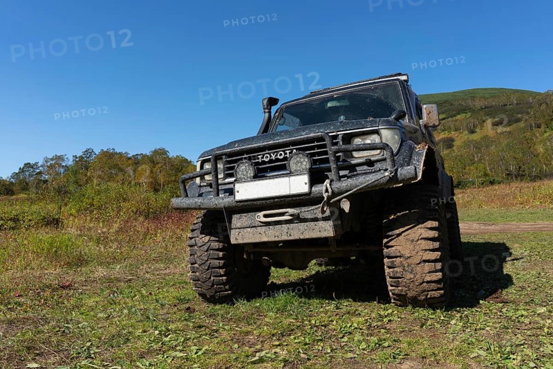Sport utility vehicle Toyota Land Cruiser Prado on mountain autumn forest landscape, popular travel destinations for climbing in clear sunny weather. Kamchatka Peninsula, Russia, September 12, 2019, Europe