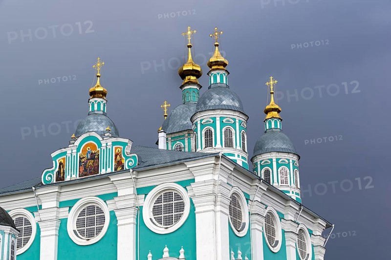 Golden domes of the Uspensky Cathedral on the background of a dark thundercloud. Smolensk, Russia, Europe