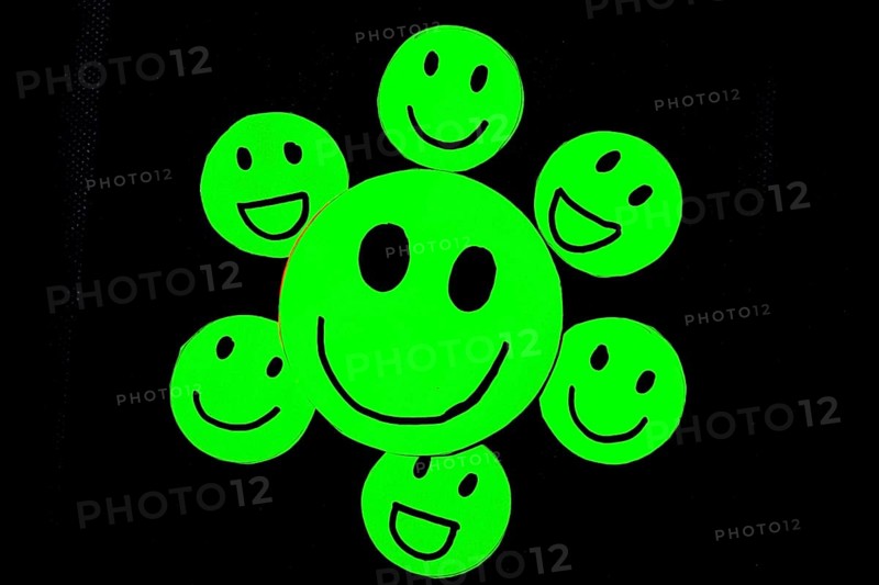 Cutout of green emoticons with smiley face on black background. Concept of well-being, good habits, health, personal care, happiness