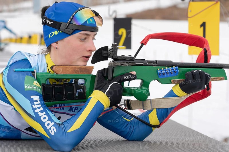 Biathlete Kryukova Arina Republic of Kazakhstan rifle shooting in prone position. Biathlete in shooting range. Open regional junior biathlon competitions East Cup. Kamchatka, Russia, April 12, 2019, Europe