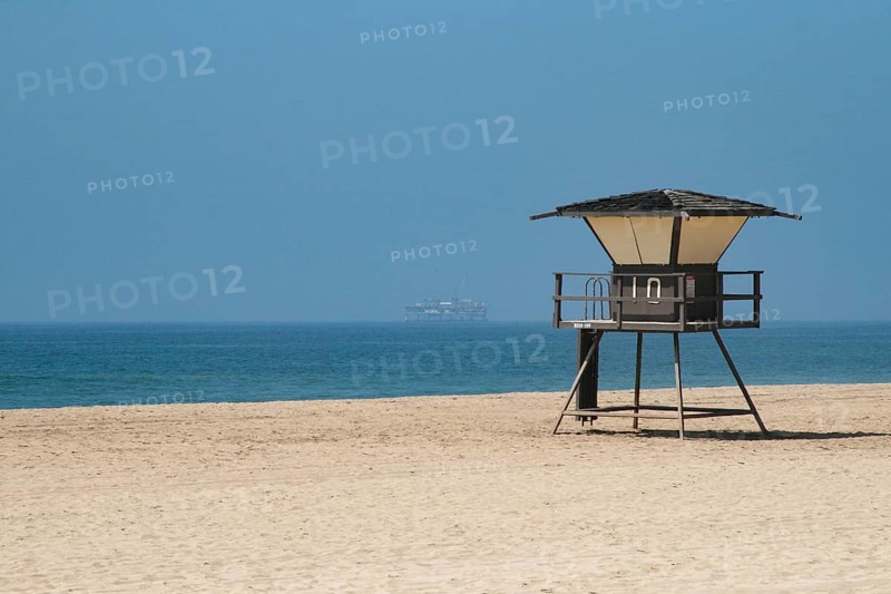 Oil rig near beach with lifeguard tower