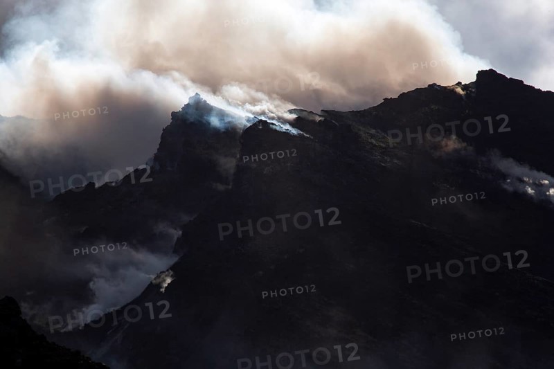 Gloomy atmosphere with smoke and steam on the summit of the volcano