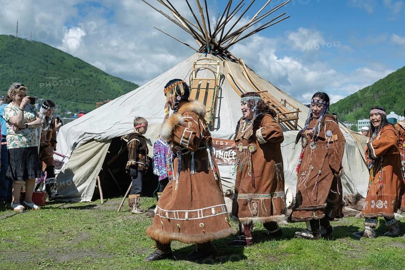 PETROPAVLOVSK CITY, KAMCHATKA PENINSULA, RUSSIA, JULY 11, 2015: Group of women in national clothing aborigine of Kamchatka expression dancing near yaranga. Public concert national folklore dance group on Fishermans Day