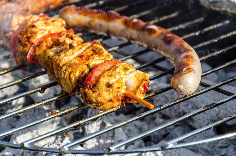 Chicken skewer and sausage on a barbecue grill