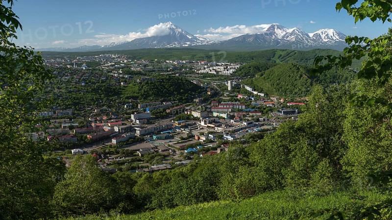 PETROPAVLOVSK CITY, KAMCHATKA PENINSULA, RUSSIAN FAR EAST, JULY 8, 2018: Summer panoramic cityscape of Petropavlovsk-Kamchatsky on background of majestic volcanoes surrounded by mountains