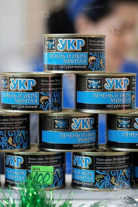 PETROPAVLOVSK CITY, KAMCHATKA PENINSULA, RUSSIAN FAR EAST, 2 DEC, 2018: Tin can natural liver pollock fish and caviar pollock (Alaska pollock, walleye pollock) standing for sale on counter at fish shop