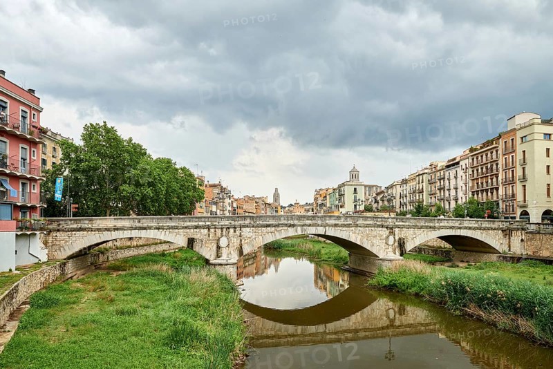 Colorful yellow and orange houses and bridge Pont de Sant Agusti reflected in water river Onyar, in Girona, Catalonia, Spain. Church of Sant Feliu and Saint Mary Cathedral at background. BRIDGE in the old town Girona, Catalonia, Spain, Europe, girones, girona, old town, view of the colorful house facades of the jewish quarter on the onyar river, Europe
