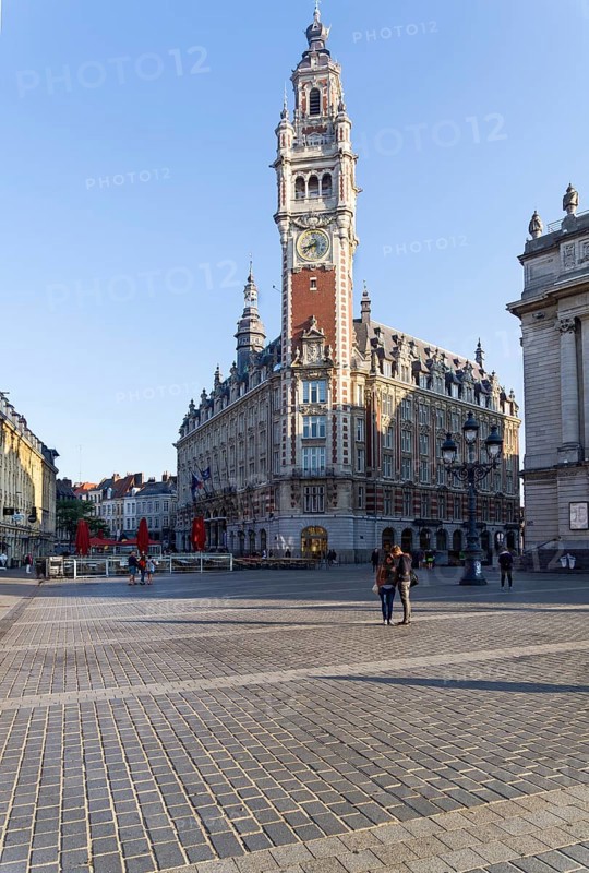 Lille, France, September 1, 2018: High clock tower on the Theater Square (Place du Theatre) in Lille, France. Sunny day in early September, Europe