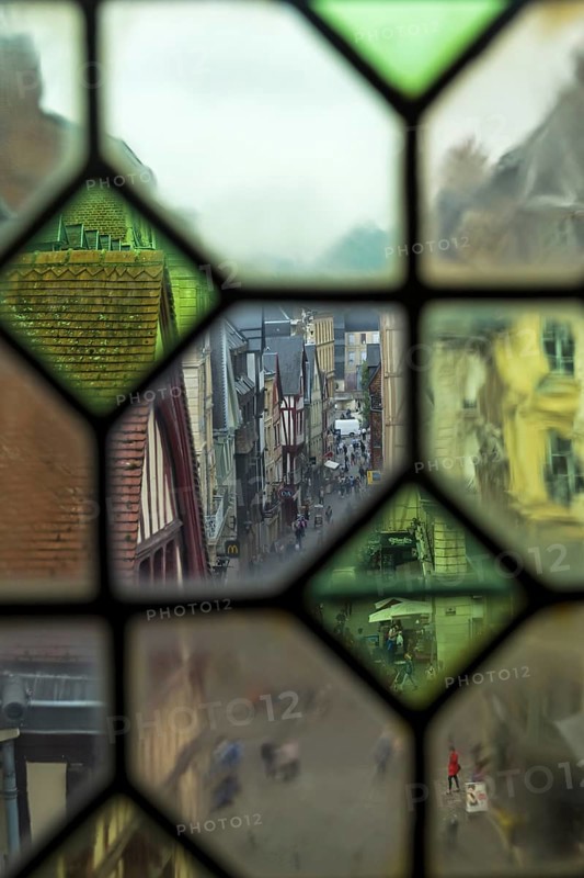 Rouen, France, August 30, 2018: View of the city street through the old window on the clock tower (Gros-Horloge) . Rouen, Normandy, France, Europe
