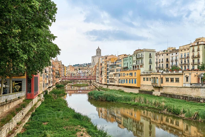 View of old town Girona, Catalonia, Spain, Europe. Summer travel. Colorful yellow and orange houses and bridge Pont de Sant Agusti reflected in water river Onyar, in Girona, Catalonia, Spain. Church of Sant Feliu and Saint Mary Cathedral at background. BRIDGE in the old town Girona, Catalonia, Spain, Europe, girones, girona, old town, view of the colorful house facades of the jewish quarter on the onyar river, Europe