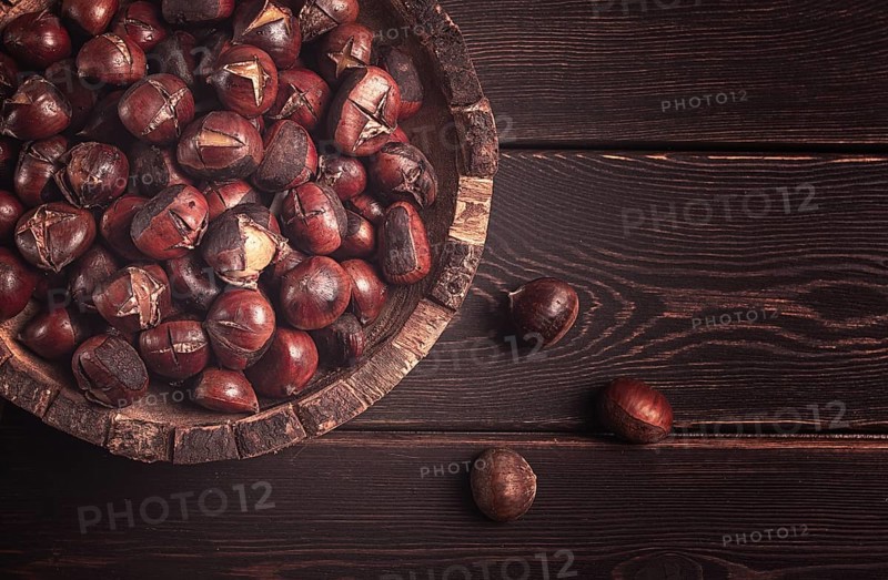 Roasted chestnuts, in a wooden plate, top view, homemade, no people