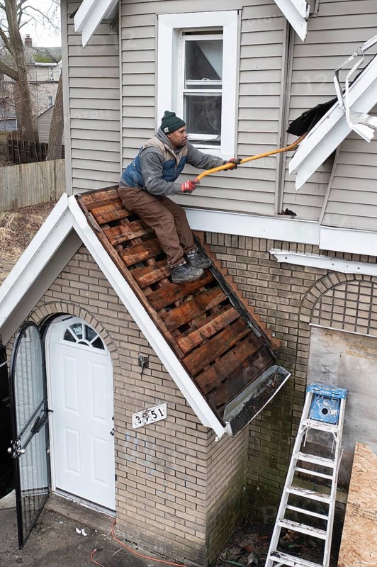 Detroit, Michigan, Workers replace a roof on a vacant house in the Morningside neighborhood. They were part of an effort by a nonprofit, the U Snap Bac Housing Corporation, to renovate several vacant houses in this street