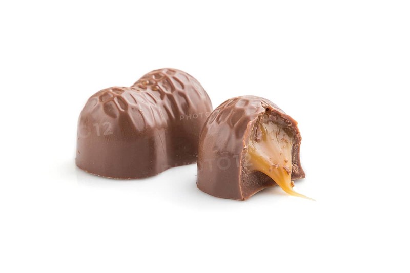 Chocolate caramel candies isolated on white background. Side view, close up