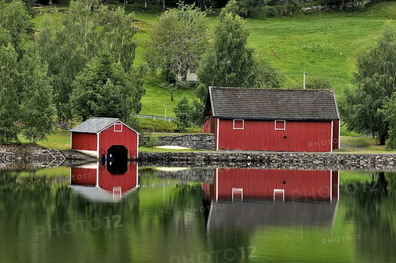 Red wooden boathouses at lake in Norway, Scandinavia