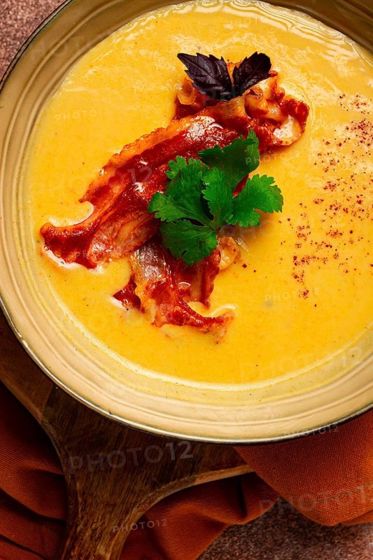 Pumpkin cream soup, curry, fried bacon, bruschetta chips, micro-greens, top view, no people