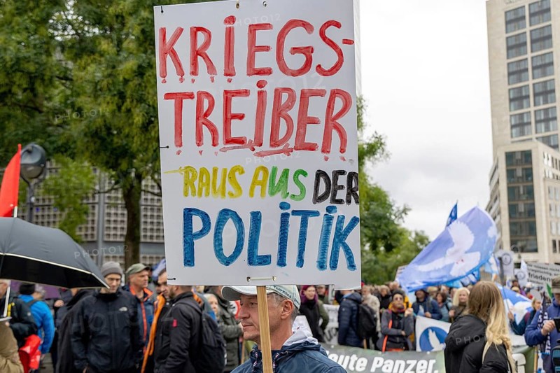 War-mongers out of politics poster at the Lay down your arms demonstration at Breitscheidplatz in Berlin. The event is directed against all wars and calls for an immediate stop to all arms deliveries. Berlin, 03.10.2024