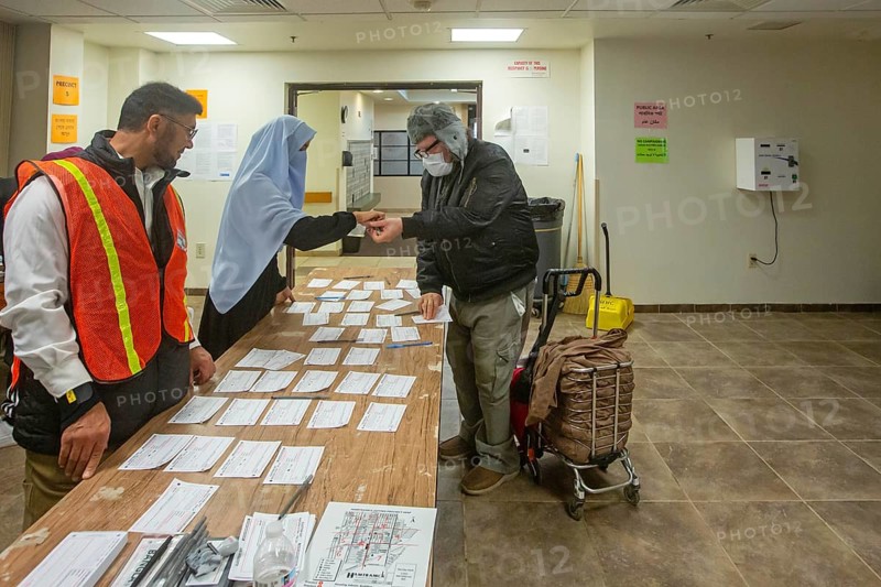 Hamtramck, Michigan USA, 5 November 2024, Election workers check in a man wanting to vote in the 2024 presidential election in Hamtramck, where the Muslim mayor, Amer Ghalib, has endorsed Donald Trump