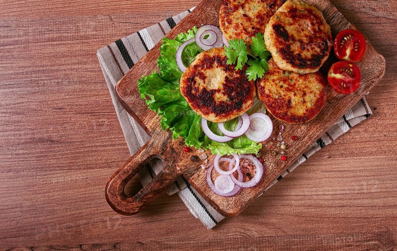 Fried chicken cutlets, minced chicken, with vegetables, on a cutting board, with vegetable salad, top view, homemade, no people