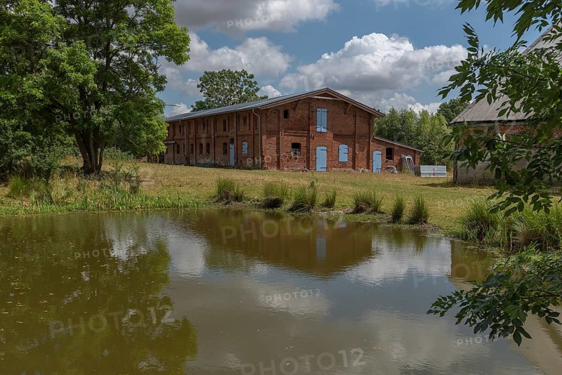 Former pigsty from 1920, in front the pond on an estate, Othenstorf, Mecklenburg-Vorpommern, Germany, Europe
