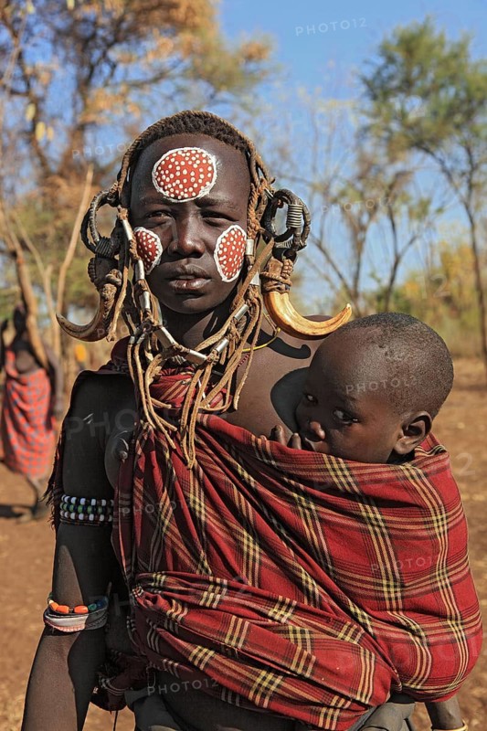 South Ethiopia, in Maco National Park, Mursi tribe, Mursi woman with baby, painted skin and headdress, Ethiopia, Africa