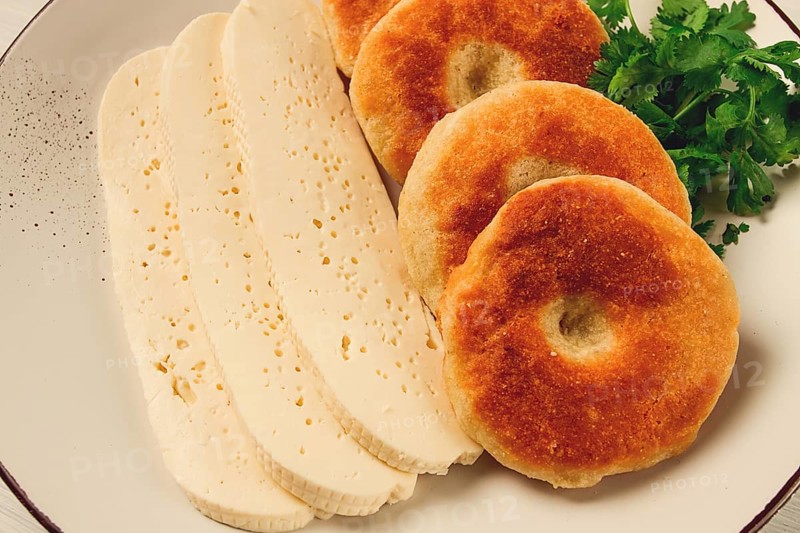 Mchadi, corn tortillas, traditional Georgian dish, corn bread, with Imeretian cheese, homemade, no people, on a light background