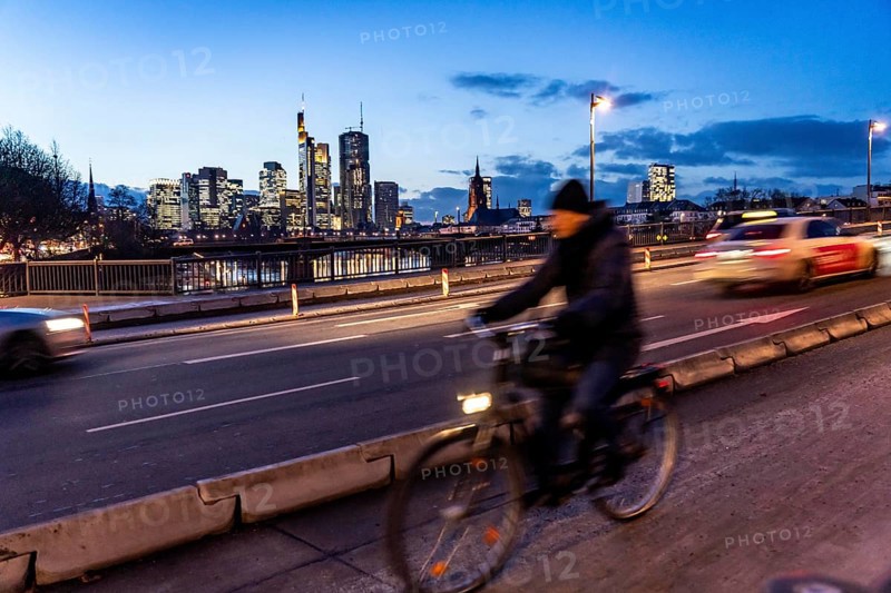 Skyline of the city centre of Frankfurt am Main, cyclist on the raft bridge, dusk, river Main, winter, Hesse, Germany, Europe