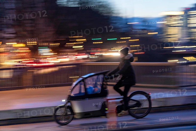 Skyline of the city centre of Frankfurt am Main, cargo bike cyclist on the rafter bridge, dusk, river Main, winter, Hesse, Germany, Europe