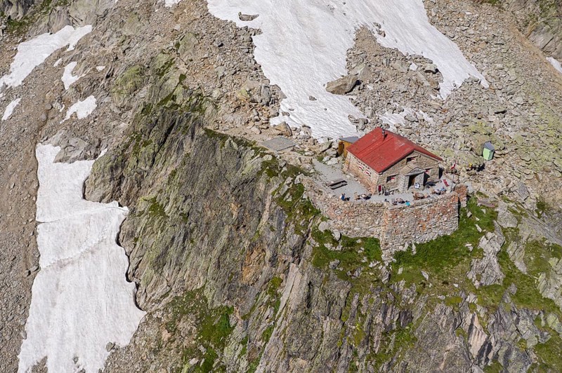 Aerial view of mountain hut Cabane de l'A Neuve, located on a steep rock formation, near La Fouly, Val de Ferret, Switzerland, Europe