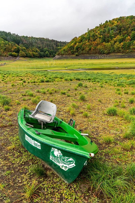 The Edersee, near Waldeck, the third largest reservoir in Germany, currently has only just under 13% of its normal level, the lake was last full in May 2022, dried up due to lack of rain, stranded fishing boat, pike hunter, the lake shore and the lake bottom is overgrown with fresh grass, Hesse, Germany, Europe