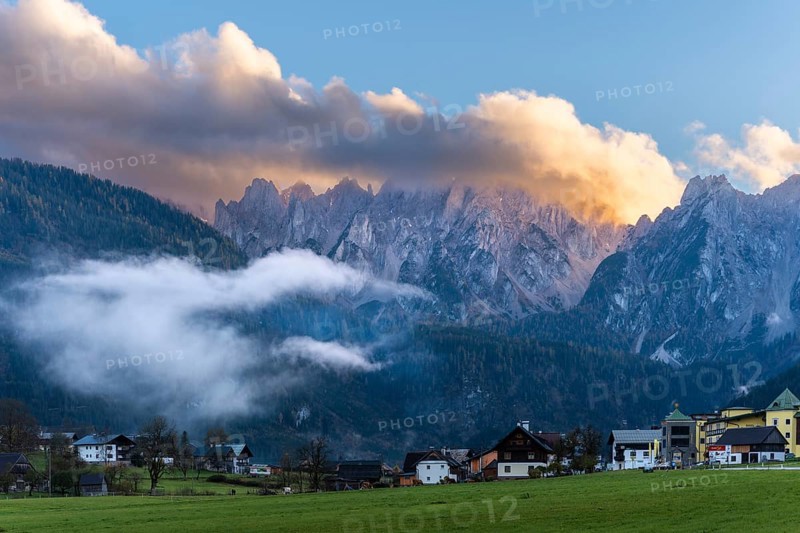 The houses of Gosau (Mittertal) with the Gosaukamm at sunset. Blue sky, bright clouds. Gosau, Gosau valley, Salzkammergut, Upper Austria, Austria, Europe