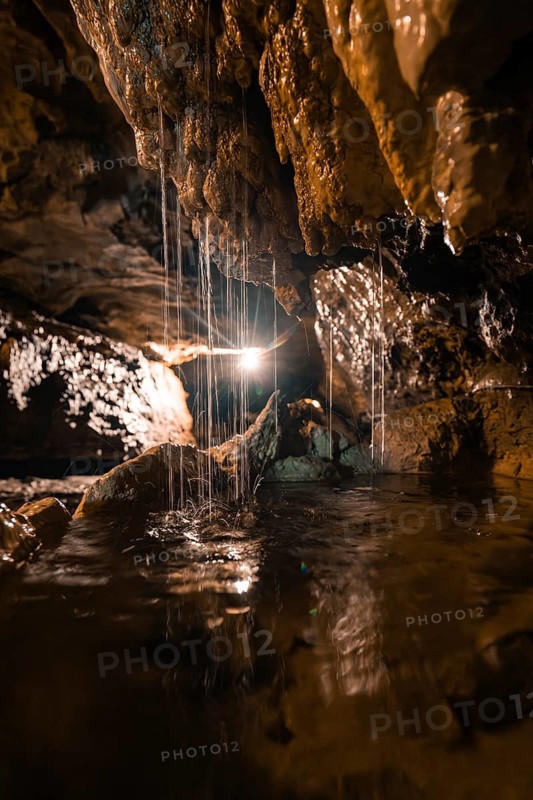 An illuminated cave room with dripping water and fascinating formations, St. Beatus Caves, Switzerland, Europe
