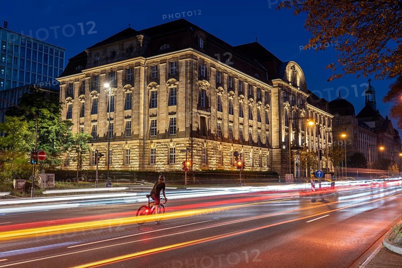 Evening city centre traffic, Cecilienallee, federal road B1, cyclist waiting in a left turn lane to continue his journey, building of the Düsseldorf Higher Regional Court