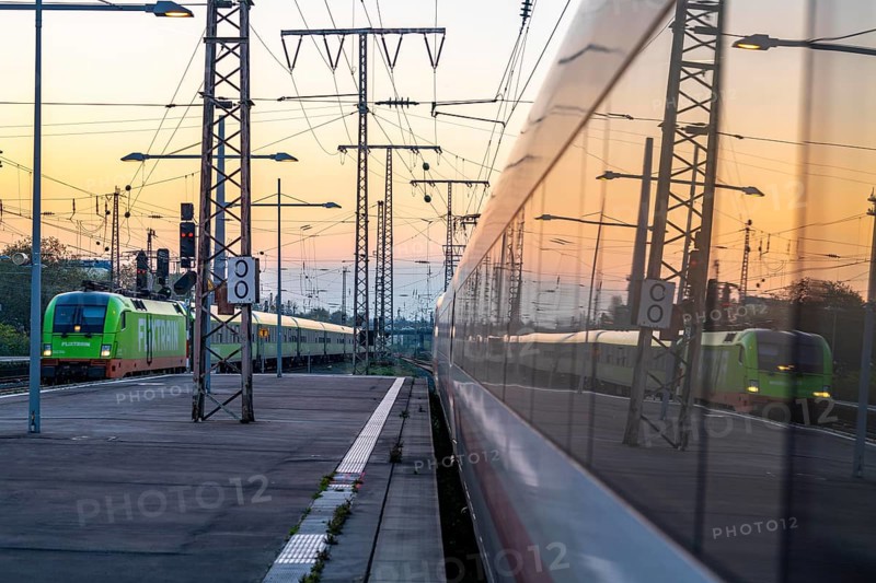 Flixtrain train arriving at Essen central station, reflected in an ICE train, dusk, North Rhine-Westphalia, Germany, Europe