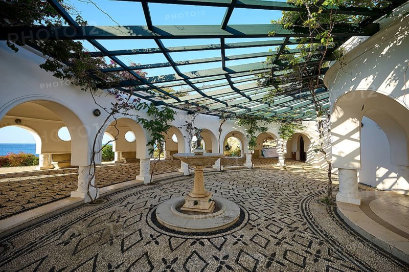 A bright, Mediterranean-inspired courtyard with cobblestones and climbing plants, overlooking the sea, thermal springs, thermal baths, thermal baths of Kallithea, Kallithea, Rhodes, Dodecanese, Greek Islands, Greece, Europe