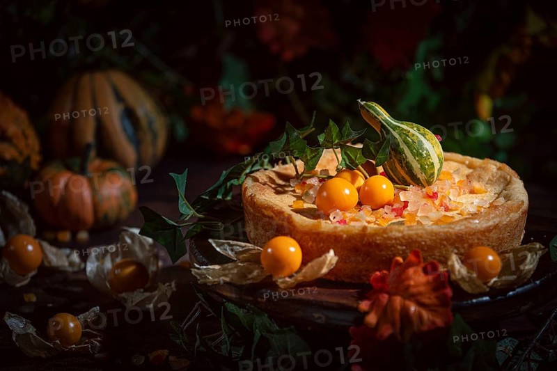 An autumnal cake decorated with yellow physalis and pumpkin in a romantic atmosphere